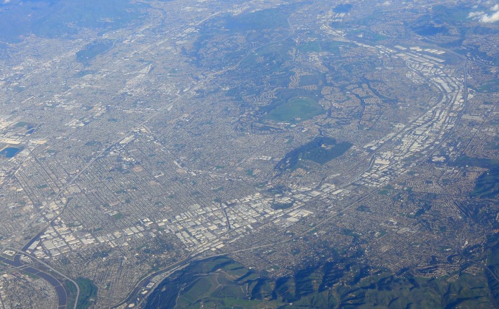 Aerial view of warehouses and business parks in the City of Industry, California, beside the San Jose Hills