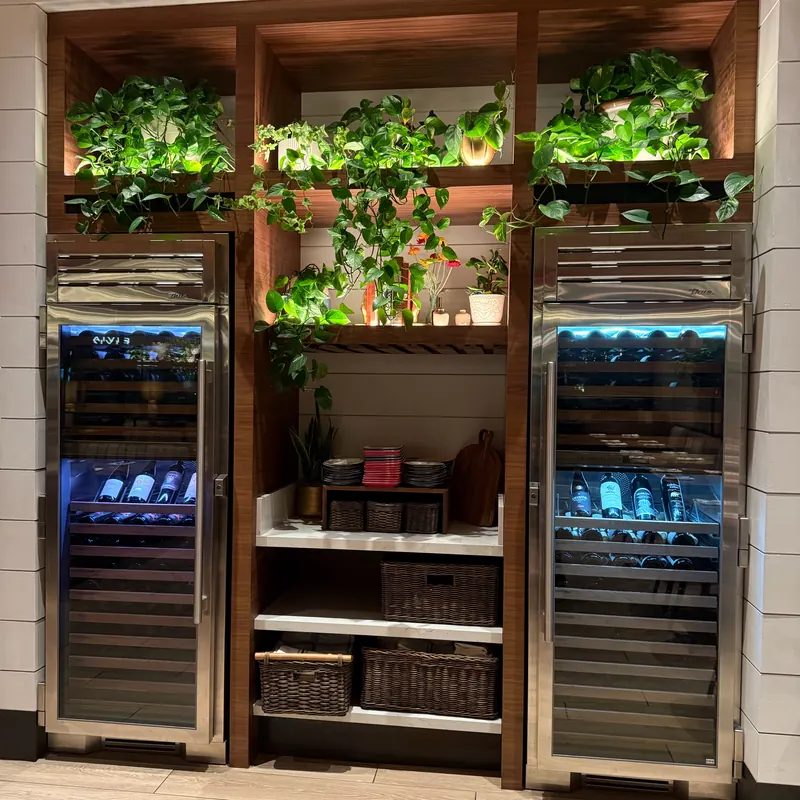 Lit wine refrigerators and shelving at North Italia Brea