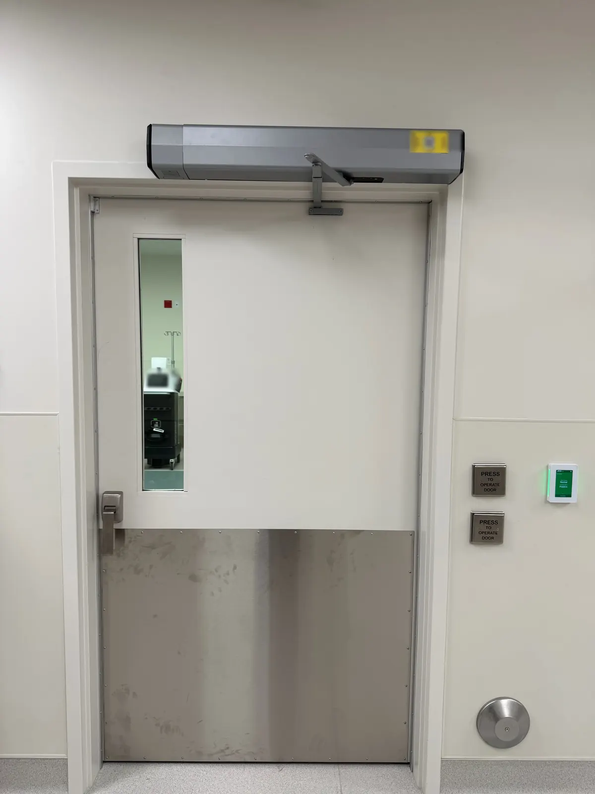 Door with an automatic door operator above it, two "press to operate door" push plates and a card reader beside it at Ortho AZ in Glendale, AZ