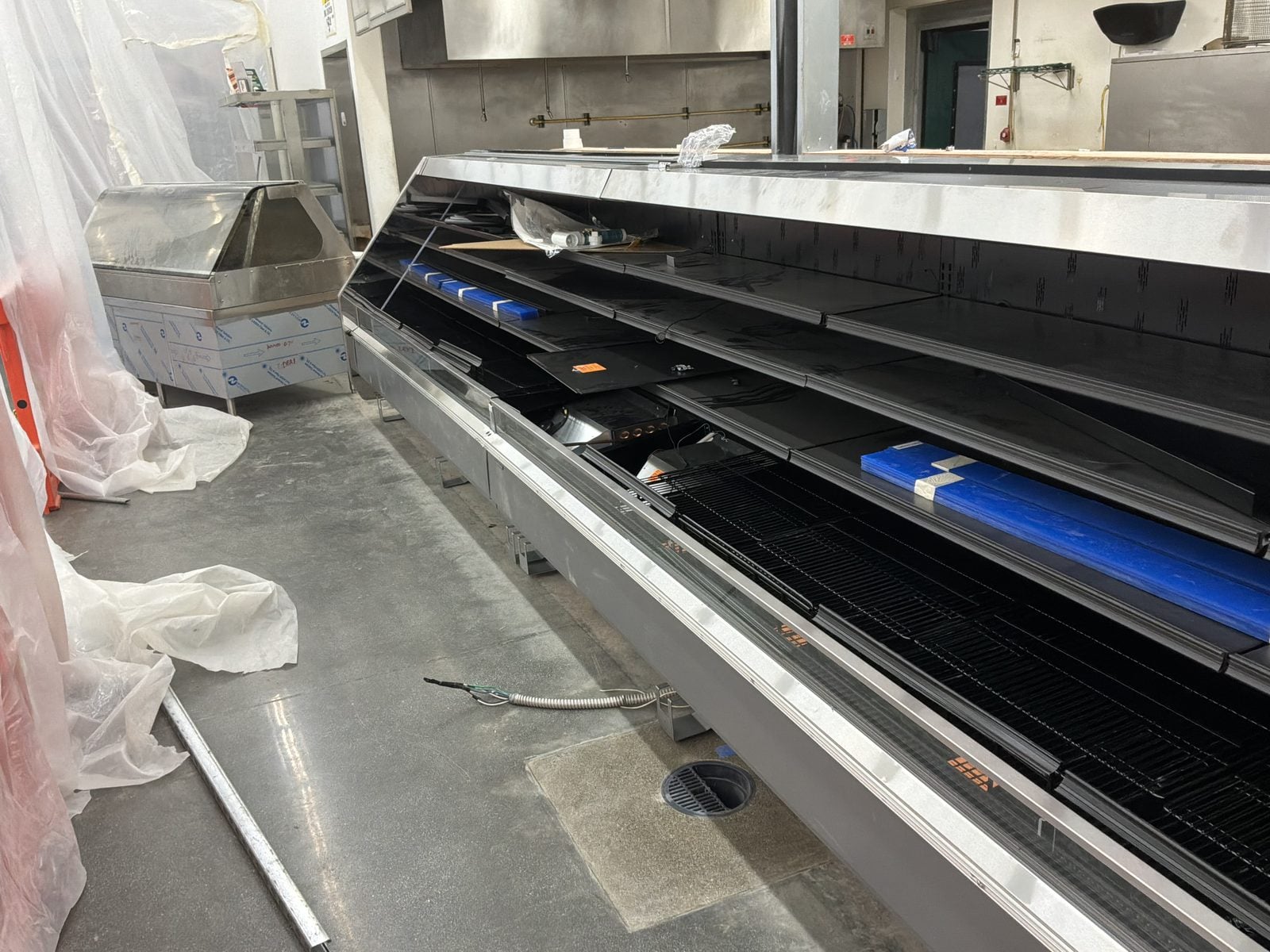 Empty refrigerated display case in a WinCo Foods store in Hemet, CA during an overnight remodel